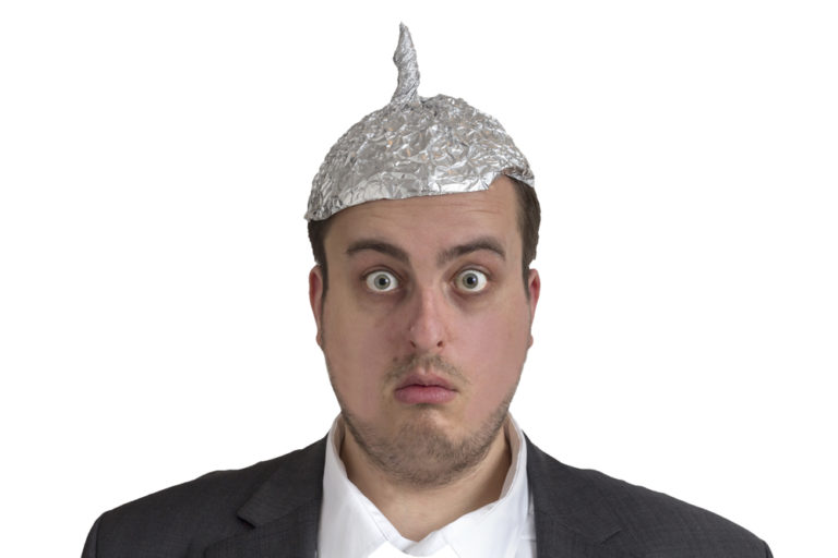 shutterstock_241641217 distraught looking conspiracy believer in suit with aluminum foil head isolated on white background