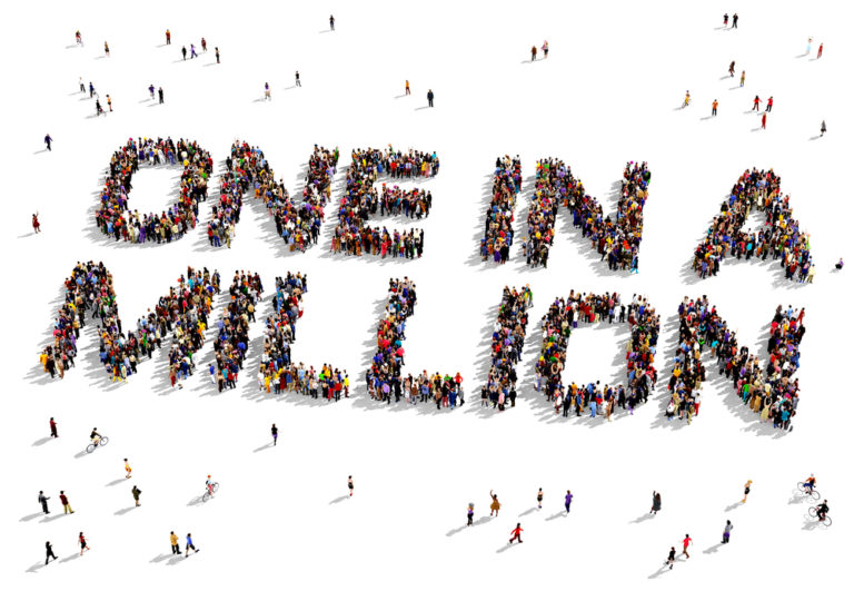 shutterstock_265074500 Large group of people seen from above gathered together to shape the text "One in a Million"