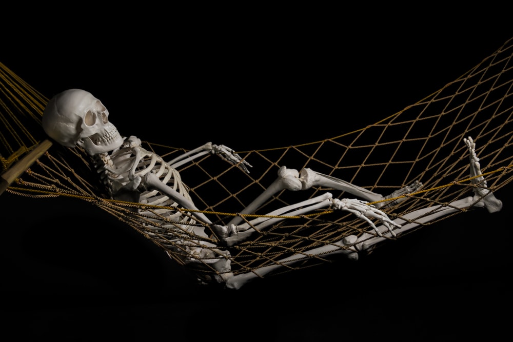 shutterstock_302516396 Human skeleton swinging on hammock
