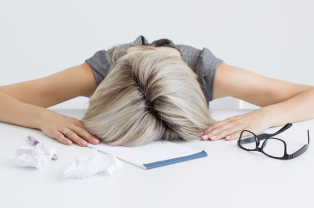 shutterstock_212138536 Overworked and tired young woman sleeping on desk