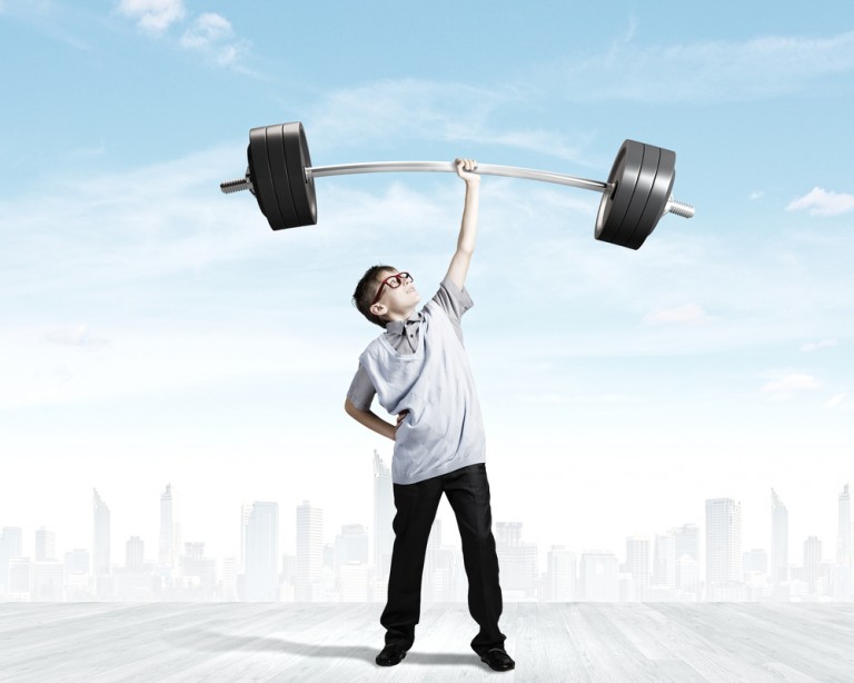 shutterstock_200446283 Cute boy of school age lifting barbell above head