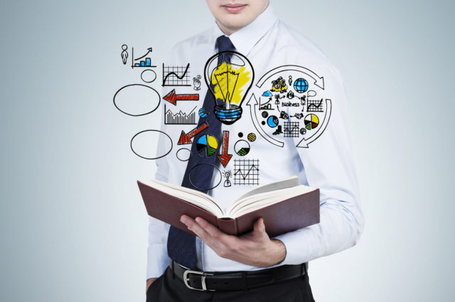 shutterstock_221662603 Businessman is reading a book with flying business management flowchart.