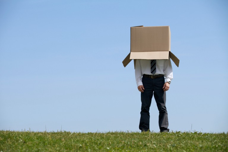 shutterstock_274693853 Man standing in park with cardboard box over his head