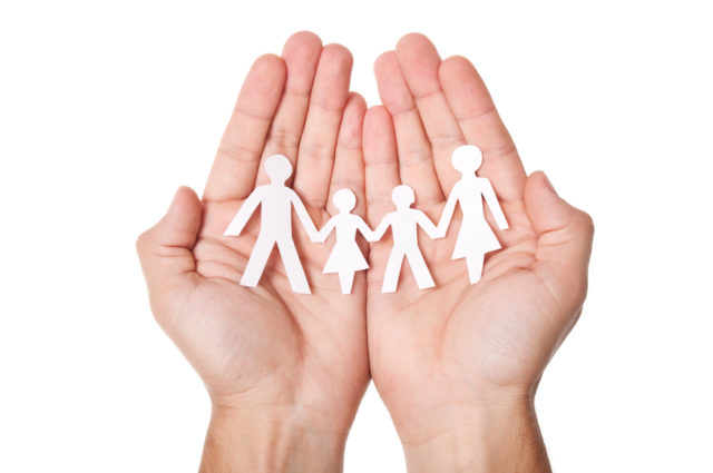 shutterstock_84928147 Paper family in hands isolated on white background