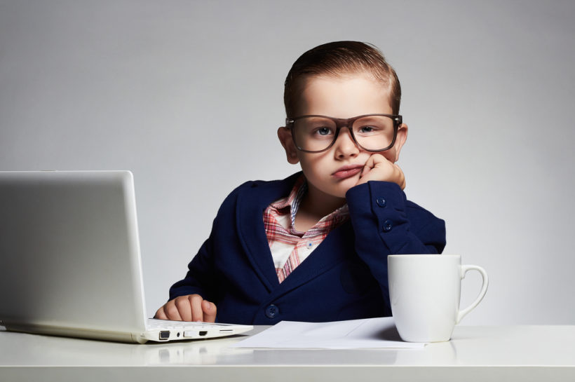 shutterstock_324808769 Boring job.Young business boy. funny child in glasses writing pen. little boss in office