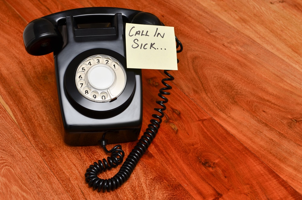 shutterstock_126649655 Retro black telephone with reminder note to call in sick
