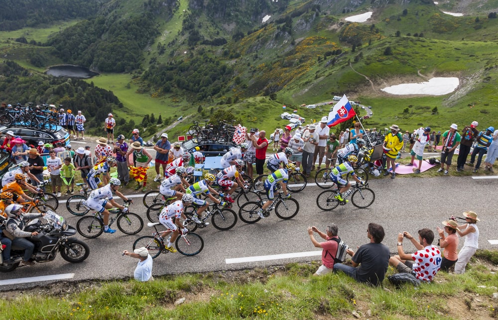 shutterstock_150825755 PORT DE PAILHERES,FRANCE- JUL 6:The peloton climbing the road to Col de Pailheres in Pyrenees Mountains during the stage 8 of the 100 edition of Le Tour de France on 6 July 2013.