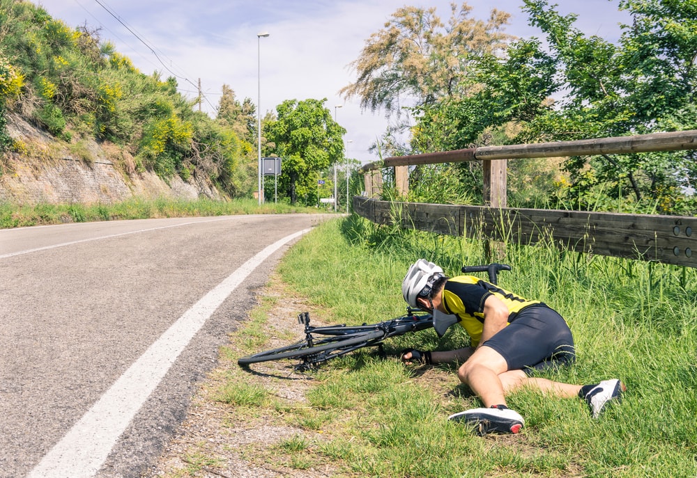 shutterstock_173976206 Bicycle accident on the road - Biker in troubles - Concept of sport failure and defeat during race competition