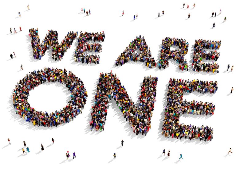 shutterstock_301844315 Large group of people seen from above gathered together to form the text "WE ARE ONE" on a white background