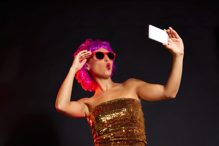 shutterstock_347262281 crazy purple wig girl selfie smartphone with fun glasses on black background