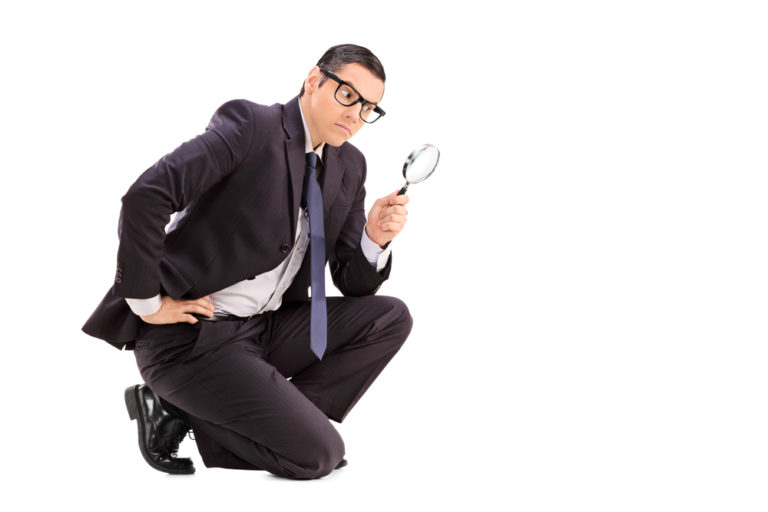 Male Inspector Looking Through A Magnifying Glass