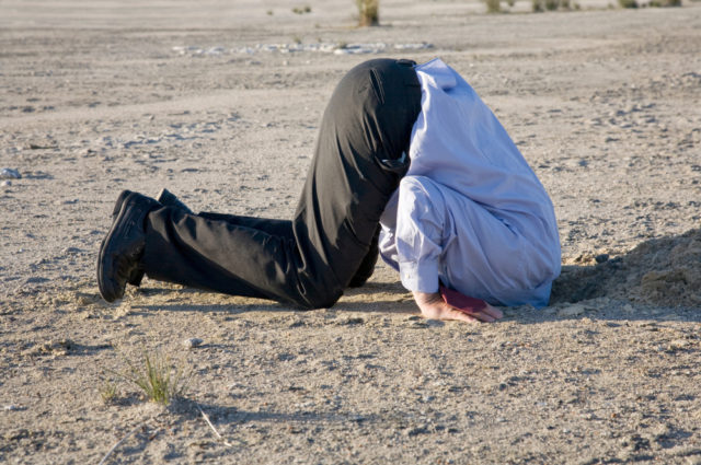 A Powerful Denial Concept, Man With His Head In The Sand. - Image