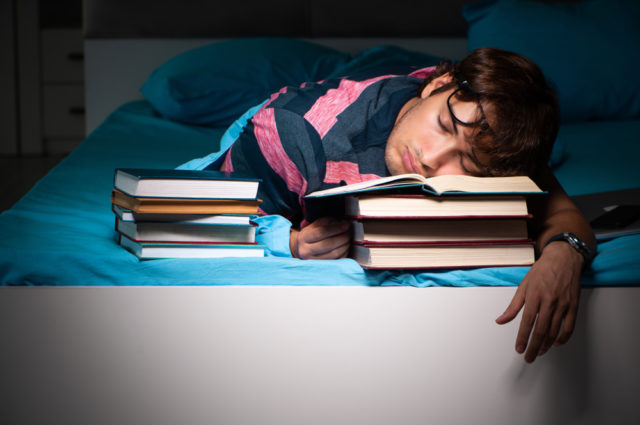 Young Student Preparing For Exams At Night At Home