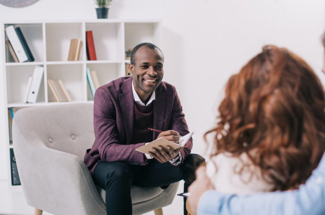 By LightField Studios Royalty-free stock photo ID: 1050440903 Smiling african american psychiatrist talking to young couple