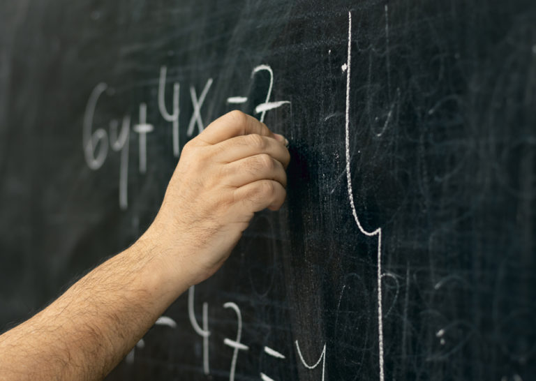 Close Up,shot,of,a,hand,holding,chalk,and,writing,mathematical