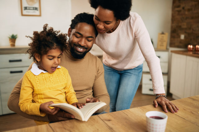 Happy,african,american,family,reading,book,together,at,home.