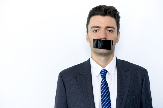 Serious,businessman,with,adhesive,tape,on,mouth