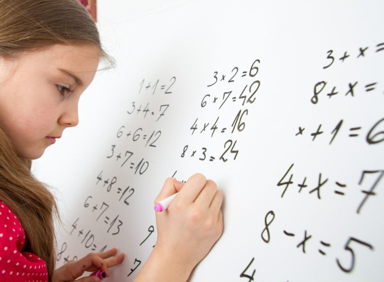 Little,schoolgirl,writing,on,blackboard