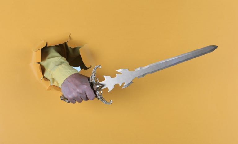 Sword,in,hand,on,yellow,paper,background