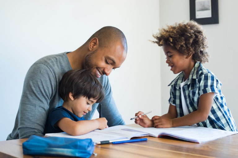 Young,black,father,helping,his,boys,with,homework.,multiethnic,brothers